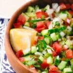 israeli salad in a brown ball with lemon wedge