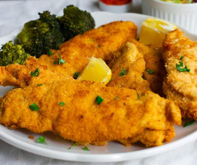 Crispy Passover Chicken Schnitzel on a white plate with broccoli